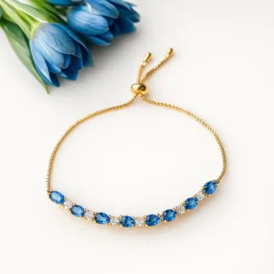 Gold adjustable bracelet with blue oval stones and crystal accents