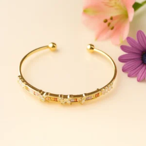 Gold open cuff with butterfly and pastel stones